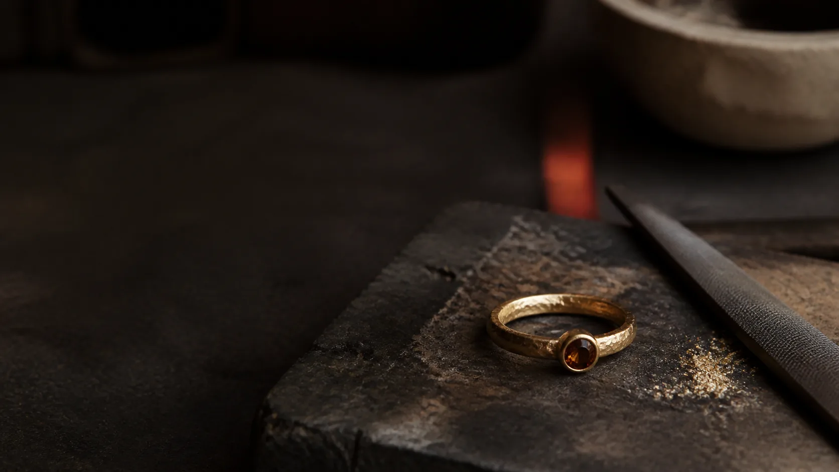 Anillo de oro hecho a mano sobre un yunque de taller